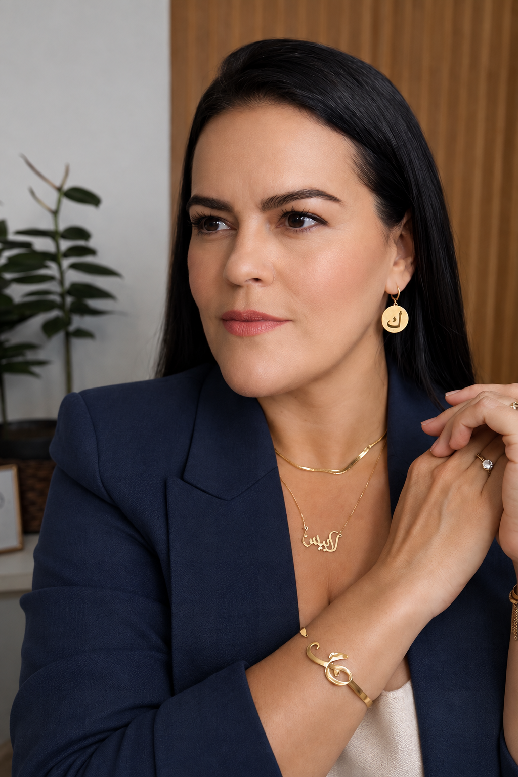 Karine Guimarães, fundadora da Que Tal Árabe, usando colar, brinco e pulseira com caligrafia árabe
